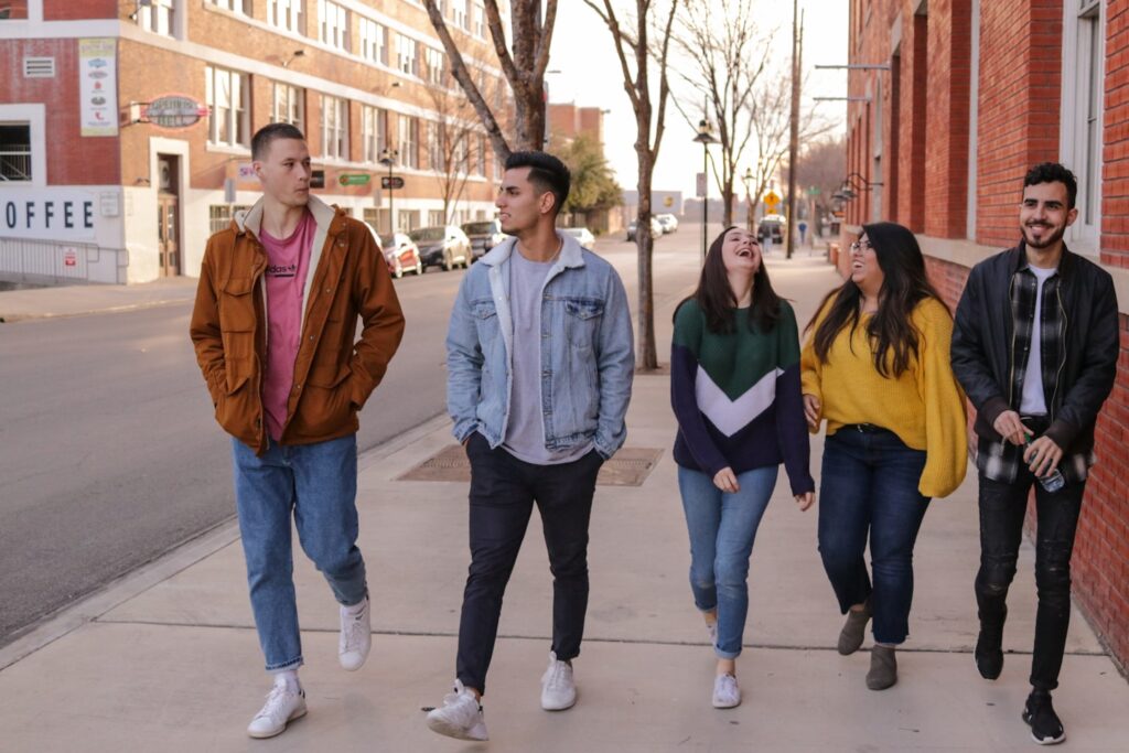 three men and laughing two women walking side by side